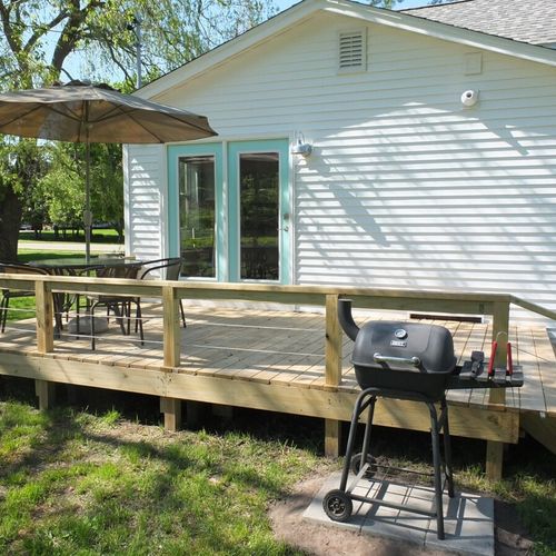 Exterior:  the deck, charcoal grill, and outdoor dining furniture.