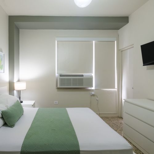 Experience ultimate comfort in our well-lit bedroom, complete with modern furnishings, blackout blinds for undisturbed sleep, and a refreshing air conditioning unit to keep you cool.