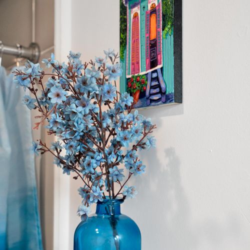 Cheerful blue floral decor & vibrant artwork add a festive, local flair.