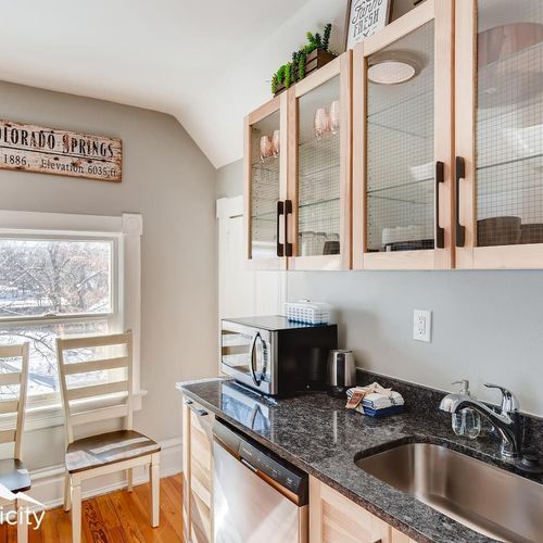 - compact kitchen corner with sink, dishwasher, microwave, and glass cabinet storage
- black granite countertops and wood accents offer a sleek cozy design
- window seating for two invites you to sip coffee and watch the morning light