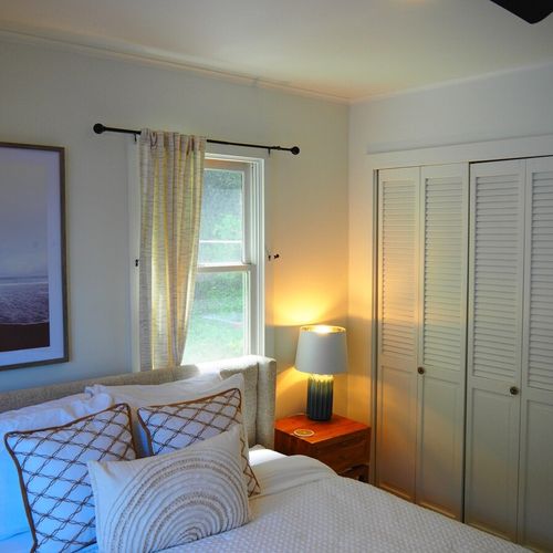 Bedroom #1:  features a king-size bed, nightstands, lamps, ceiling fan, chair, desk, and a closet.