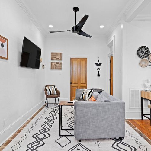 Cozy living room w/ warm tones & a peek into the fully equipped kitchen.