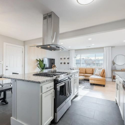 - open concept layout lets you cook while staying connected to the living room
- center island with gas range & bar seating creates the perfect space for entertaining
- clean lines, bright tones & stylish fixtures tie the kitchen & lounge beautifully