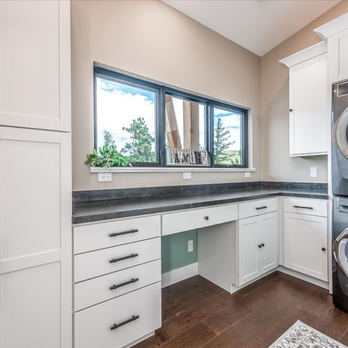 Dedicated laundry room with cabinets, generous counter space and a stacked washer & dryer set.