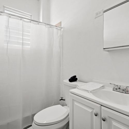 Indulge in tranquility within our pristine white bathroom, offering a serene escape from the hustle and bustle of the day.