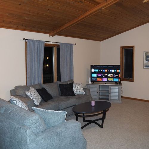 Living room:  large and comfy living room with a ceiling fan, lots of comfy seating, two coffee tables, live streaming television with roku, and a wet bar.