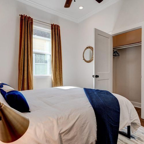 Sunlit bedroom corner w/ navy accents & a warm, inviting atmosphere.