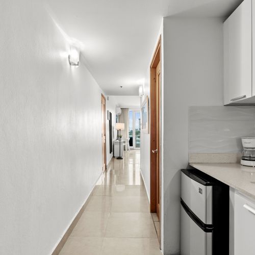 Inviting hallway with a glimpse of your bright, well-appointed studio and convenient kitchenette.