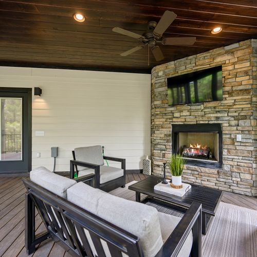 A couch and chairs surround the fireplace on the covered deck!