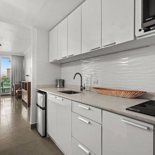 Sleek, compact kitchen leading to a bright, spacious studio with stunning views.