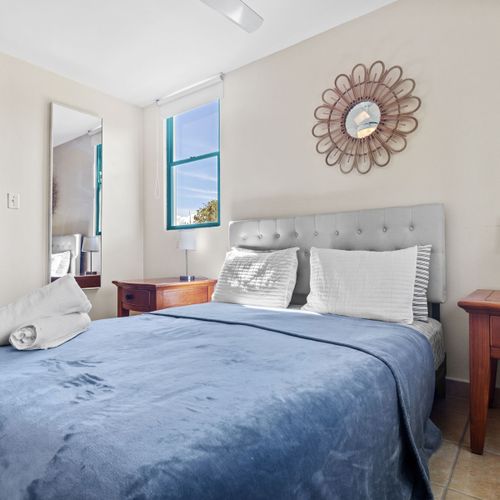 Experience tranquility in our Airbnb haven with a cozy queen-sized bed and plush blue comforter.