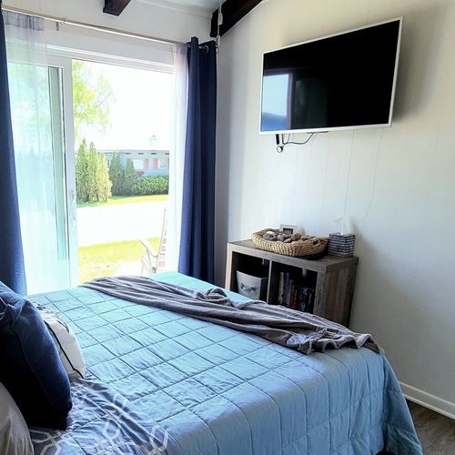 Bedroom #1:  bedroom #1 features a queen-size bed, private entrance, a great view of crystal lake, a ceiling fan, matching nightstands with lamp, a closet, and its own television.