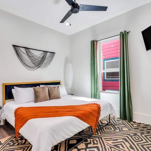 Downstairs king bedroom w/ bold orange & green accents for a vibrant vibe.