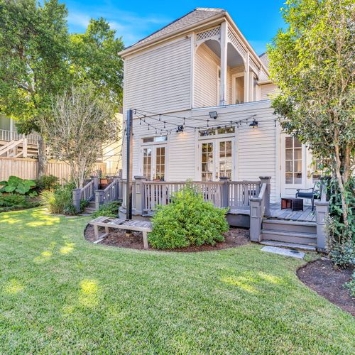 Expansive backyard with a well-maintained lawn, mature trees, and a charming deck perfect for outdoor gatherings.