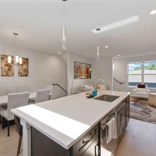 White ceilings and natural light connect the kitchen and living room seamlessly.