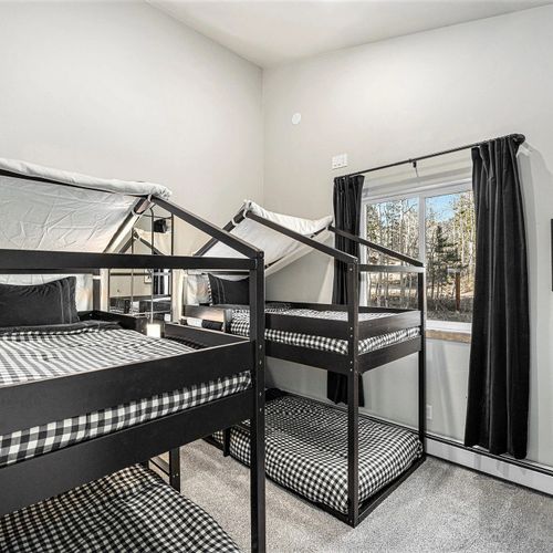 Perfect for the kids or a group of friends, this cozy guest room features two sets of bunk beds for a fun and comfortable stay.