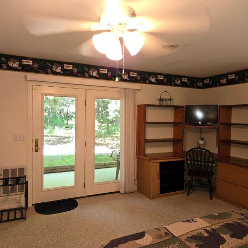 Bedroom #1:  the cabin has a large primary bedroom with a queen-size bed, desk, comfy chair, ceiling fan, dresser, and closet.