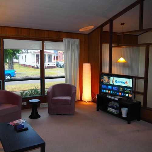 Living room:  very comfortable living room with great natural lighting, a sofa, comfy chairs, and live streaming television.