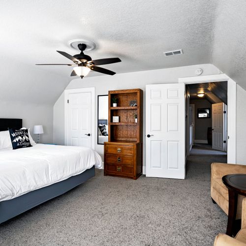 This spacious bedroom features a king size bed, end tables, closet, and plenty of space for your luggage. There are lounge chairs and a table provided for your convenience.