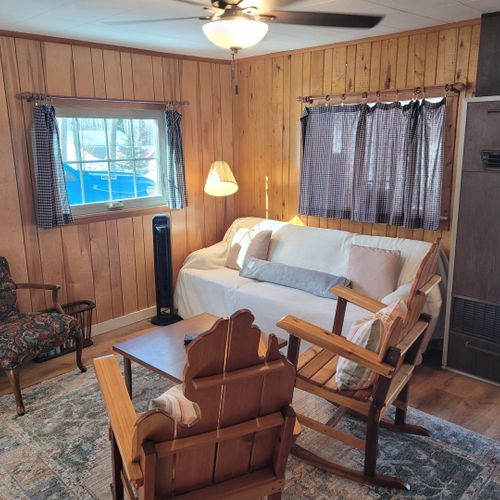 Living room #1:  the home has a cozy living room in the center of the cabin with a sofa, 3 chairs, and a coffee  table.