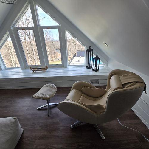 NOUHAUS Heated Classic Massage Chair is a welcome addition to the attic space. This full-body and spot massaging recliner comes with an ottoman, Bluetooth speaker, and in-chair charger, and also functions as a portable Shiatsu body massager.