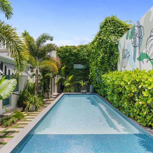 Lush garden oasis surrounds the pool.