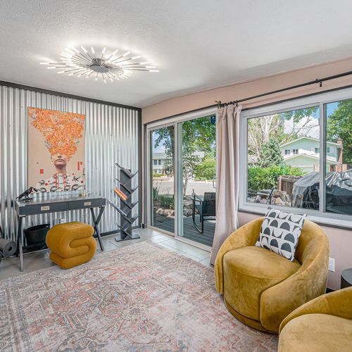 The sunroom doubles as a productive workspace, featuring a functional office desk and chair bathed in natural light, creating an inspiring environment for work or study.