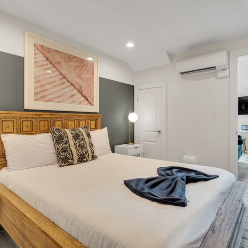 Natural wood bed frame & cozy bedding w/ easy access to the living space.