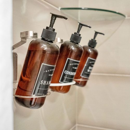 Refillable, eco-friendly bath essentials—shampoo, conditioner, and body wash provided for a refreshing stay.
