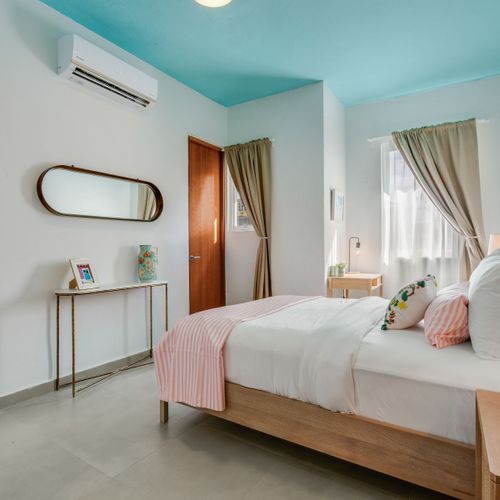 A sizable sleeping space with a wide window and a new bed.