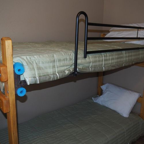 Main room:  features a small dining table with chairs, kitchenette  / sink, one twin-on-full bunk bed, and one twin-on-twin bunk bed.