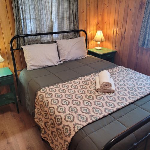 Overall:  very comfy bedroom with a queen-size bed, nightstands, lamps, a dresser, and a mirror.
