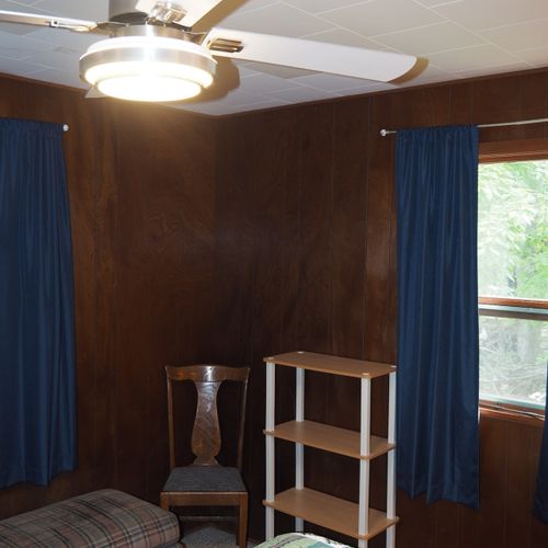 Bedroom #1:  features a queen-size bed, dresser, chair, lamps, and a ceiling fan.