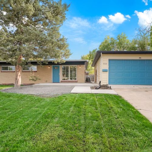 - welcoming curb appeal with vibrant blue door, wide windows, and fresh cut lawn
- detached garage and long driveway provide easy parking for multiple cars
- clean, cheerful arrival that sets the tone for a great stay