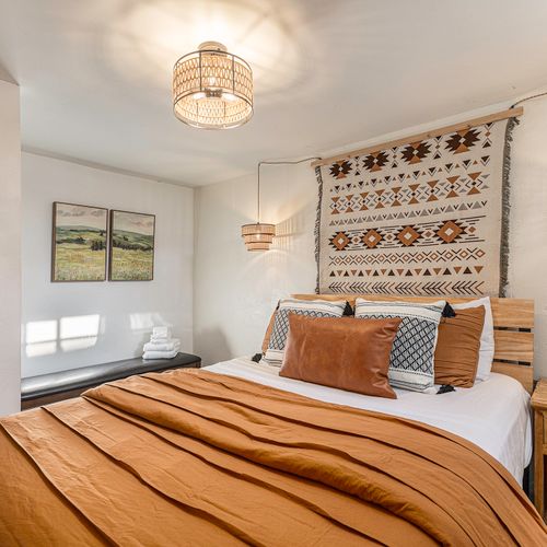 Discover a stylish retreat in the lower level bedroom, featuring a comfortable queen-size bed with fresh linens and cozy bench nook.