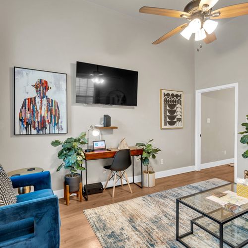 Dedicated workspace w/ a desk, wall-mounted TV & lounge chair — work & relax.