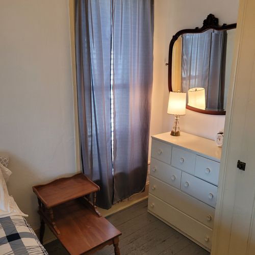BEDROOM #2 (MAIN FLOOR):  Features a full-size bed, nightstand, chair, dresser, mirror, and closet.