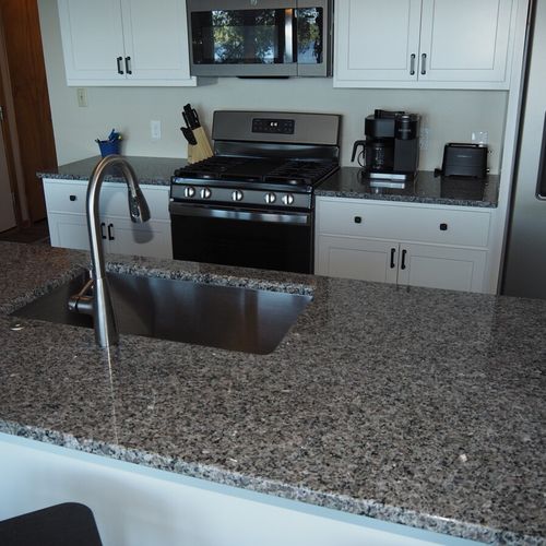 Kitchen:  newly remodeled and features a gas stove and stovetop, refrigerator, microwave oven, dishwasher, keurig coffee maker, toaster, island with sink, barstools, lots of counter space and cabinets, and a good supply of cooking & dining utensils.