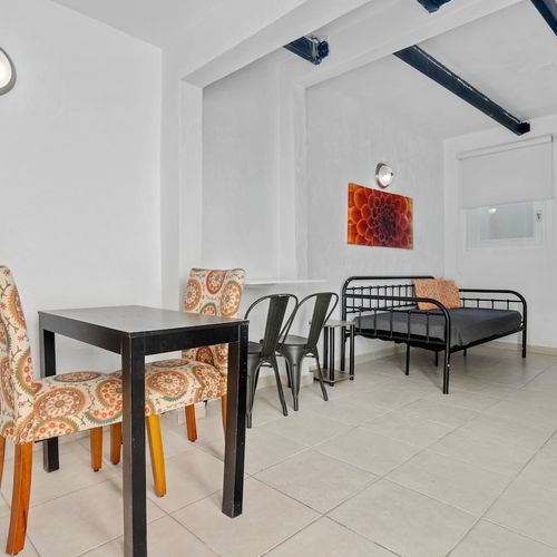 Relish your meal in a brightly illuminated dining space, showcasing a contemporary table against a backdrop of pristine white walls.