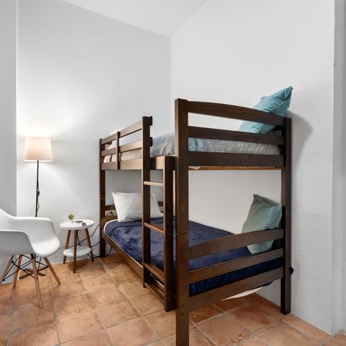 A cozy bunk bed arrangement in a sleek, modern minimalist room—ideal for friends or families traveling together.