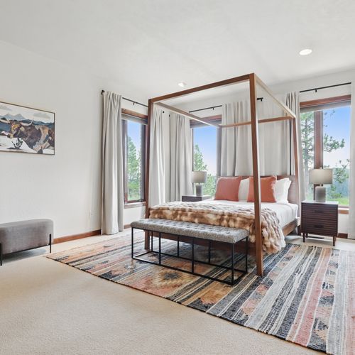 The master bedroom blends stylish contrasts with peaceful nature views.