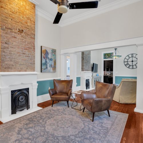 Inviting sitting area w/ a fireplace, leather chairs & teal accents.