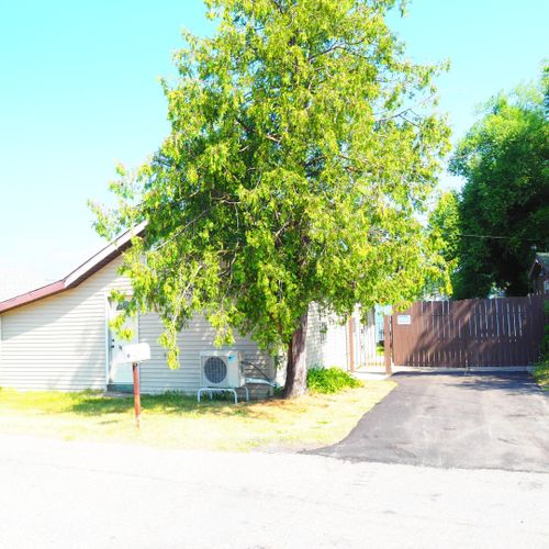 Exterior:  the front of the house and driveway in the summer