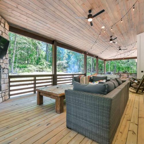 An oversized outdoor sectional is placed around the fireplace and tv.