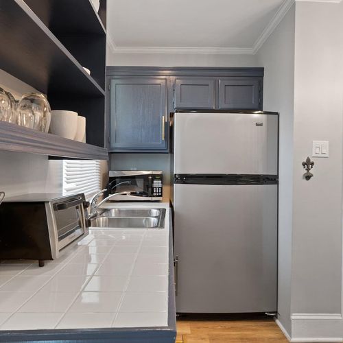 Fully stocked kitchen w/ stainless steel fridge & sleek cabinetry.