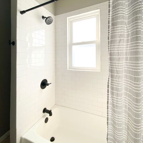 The guest bathroom has a shower and tub set up