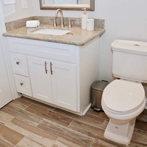 Spotless second hall bathroom w/ a white vanity, sink & toilet.