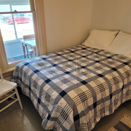 BEDROOM #2 (MAIN FLOOR):  Features a full-size bed, nightstand, chair, dresser, mirror, and closet.