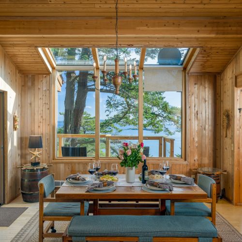 Dining under the trees and stars with an open kitchen and windows all around.