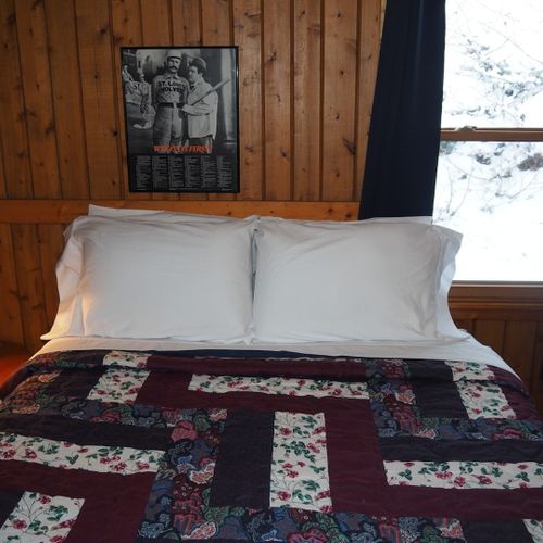 Bedroom #2 (main floor):  features a queen-size bed, nightstand with a lamp, a dresser, and a closet.